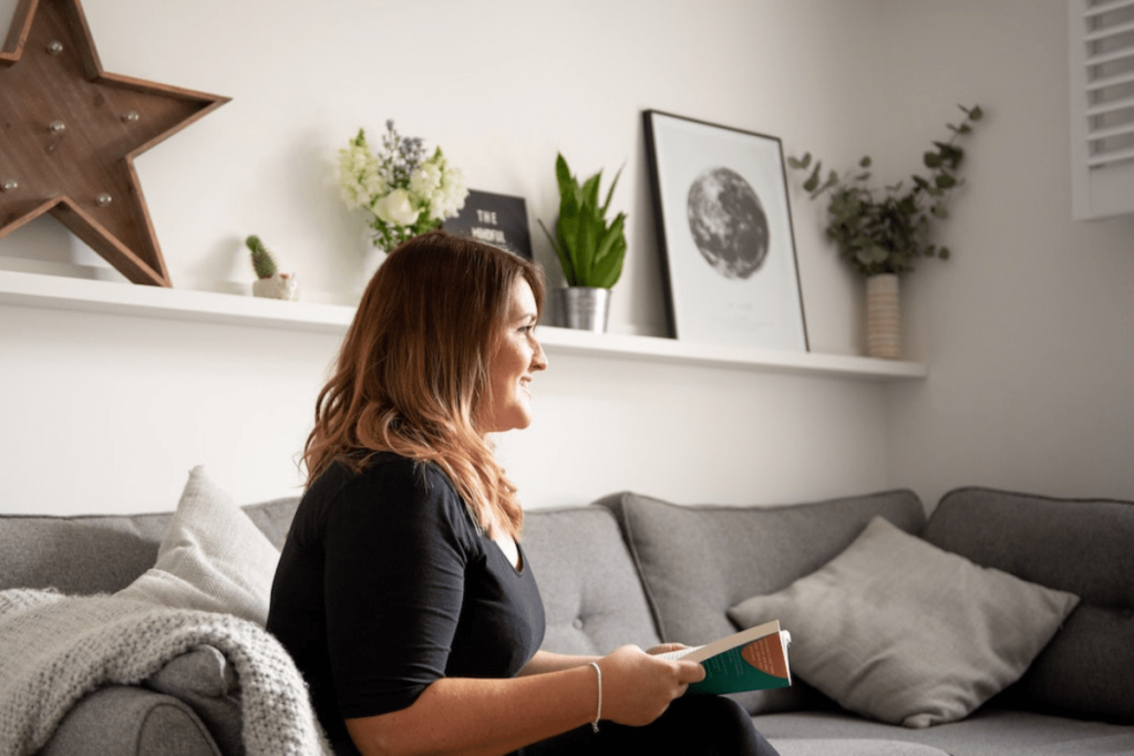 woman relaxing at home on the couch with book