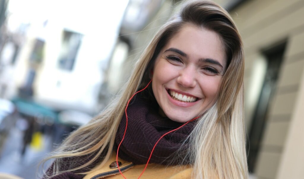 Happy Woman in Purple Scarf Listening to Music