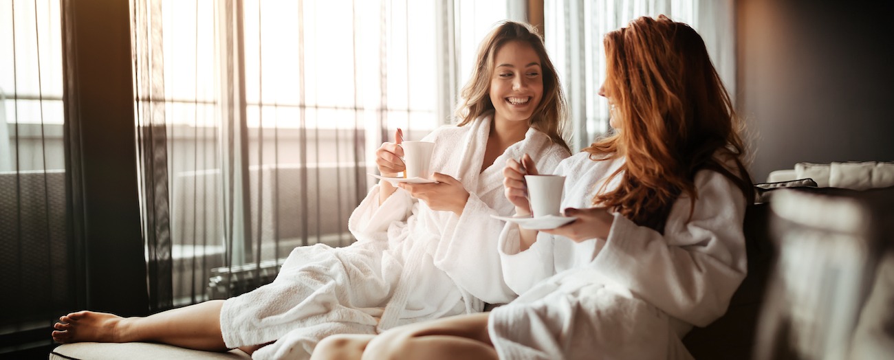 Women,Relaxing,And,Drinking,Tea,In,Robes,During,Wellness,Weekend