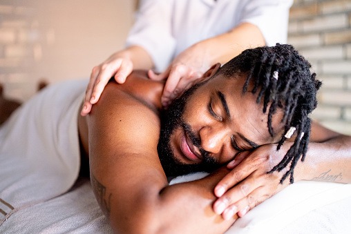Mid adult man receiving massage on shoulders at a spa